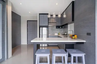 a kitchen with a large white island with stools at Tropics Pool View 2BR Kamala Apartment CTG P605-6, near Beach in Kamala Beach