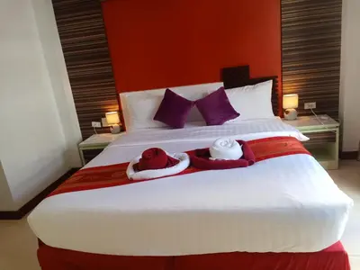 a bedroom with a large bed with two stuffed animals on it at Patong Max Value Hotel in Patong Beach