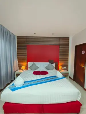 a large bedroom with a large white bed with a red headboard at Patong Max Value Hotel in Patong Beach