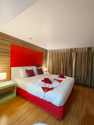 a bedroom with a large bed with a red headboard at Patong Max Value Hotel in Patong Beach