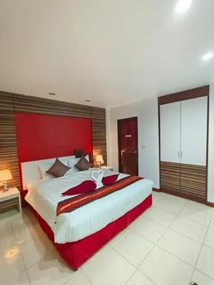 a large bedroom with a large bed with a red headboard at Patong Max Value Hotel in Patong Beach