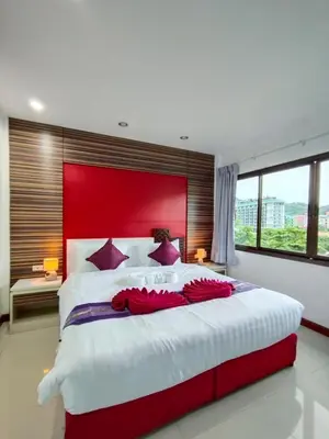a large bedroom with a large bed with a red headboard at Patong Max Value Hotel in Patong Beach