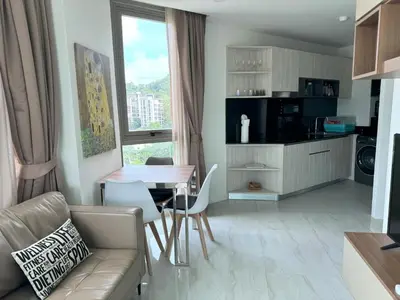 a kitchen and living room with a table and a couch at Apartment with panoramic views at Oceana by Lofty in Kamala Beach