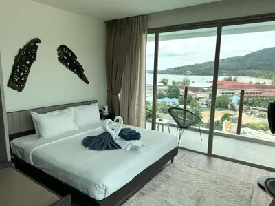 a bedroom with a bed and a large window at Apartment with panoramic views at Oceana by Lofty in Kamala Beach
