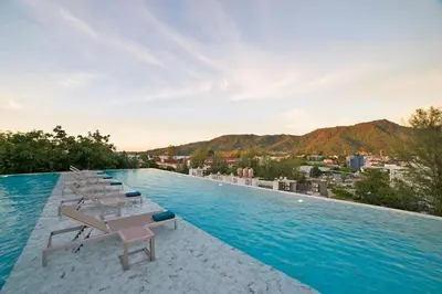 a large swimming pool with lounge chairs and a city at Apartment with panoramic views at Oceana by Lofty in Kamala Beach