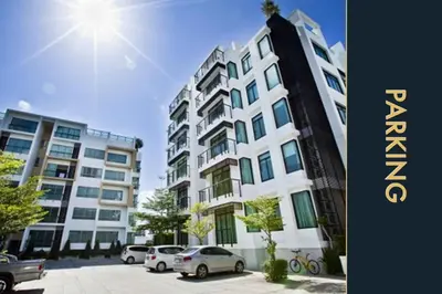 a large building with cars parked in a parking lot at Luxury Apartment at a Bargain in Kamala Beach
