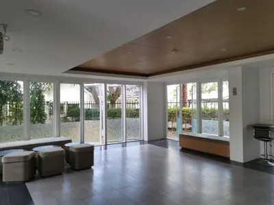 a living room with a couch and chairs and windows at 7 Floor - Mountain view Studio room at OZC near Kata beach in Kata Beach
