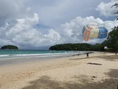a person flying a kite on a beach at 7 Floor - Mountain view Studio room at OZC near Kata beach in Kata Beach