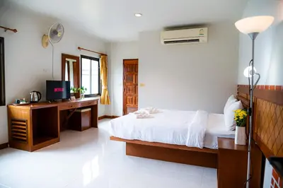 a bedroom with a bed and a desk with a television at Diamond Place Ao Nang in Ao Nang Beach