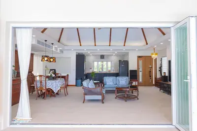 a living room with a table and chairs at Coco Golf Villa in Ban Huai Luk (1)