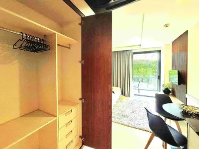 a kitchen with a cupboard and a dining room with a table at Studio Apartment 400m from Rawai Beach in Phuket Town