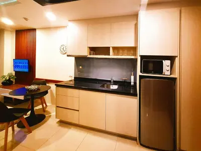 a kitchen with a stainless steel refrigerator and a table at Studio Apartment 400m from Rawai Beach in Phuket Town