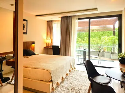 a bedroom with a bed and a balcony at Studio Apartment 400m from Rawai Beach in Phuket Town