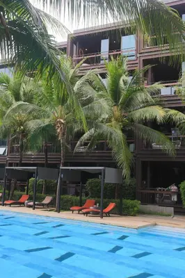 a hotel with palm trees and a swimming pool at Saturdays by Holy Cow, pool view in Rawai Beach