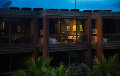 a building with balconies and tables and chairs at night at Saturdays by Holy Cow, pool view in Rawai Beach