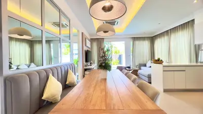 a dining room with a long table and chairs at Kamala Garden View Baan Ratri 4 in Kamala Beach