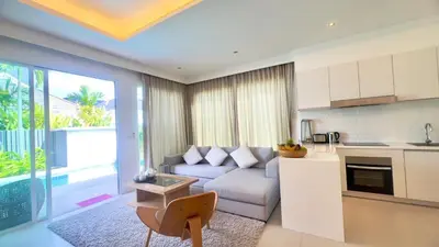 a kitchen and living room with a couch and a table at Kamala Garden View Baan Ratri 4 in Kamala Beach