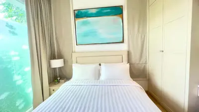 a bedroom with a bed and a window at Kamala Garden View Baan Ratri 4 in Kamala Beach