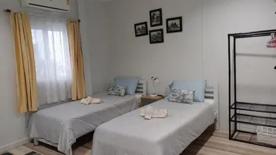 two beds sitting next to each other in a room at B&N House in Nai Yang Beach