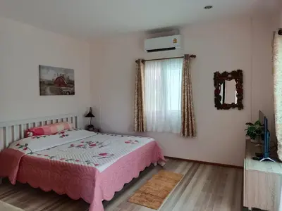 a bedroom with a pink bed and a window at B&N House in Nai Yang Beach