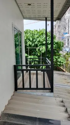 an open door of a building with a balcony at B&N House in Nai Yang Beach
