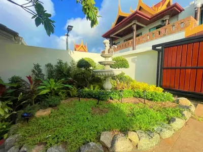 a garden in front of a building with a fountain at Vipa Seaview Villa in Patong Beach