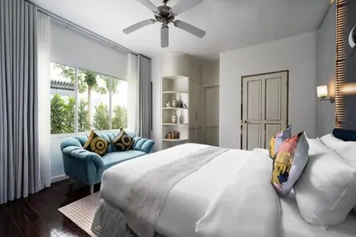 a bedroom with a large white bed and a blue couch at Vipa Seaview Villa in Patong Beach