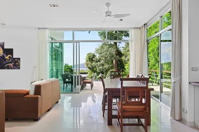 a living room with a table and a couch at Kamala Hills Naka - Villa 15 in Kamala Beach
