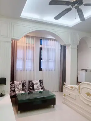 a living room with a couch and a ceiling fan at บ้านพัก น้ำตกกะทู้ in Ban Huai Luk (1)