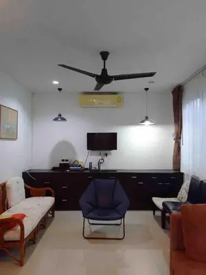 a living room with a couch and a ceiling fan at บ้านพัก น้ำตกกะทู้ in Ban Huai Luk (1)
