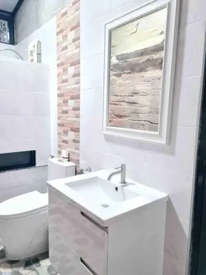 a white bathroom with a sink and a toilet at บ้านพัก น้ำตกกะทู้ in Ban Huai Luk (1)