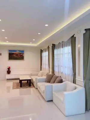 a living room with two white couches and a table at บ้านพัก น้ำตกกะทู้ in Ban Huai Luk (1)