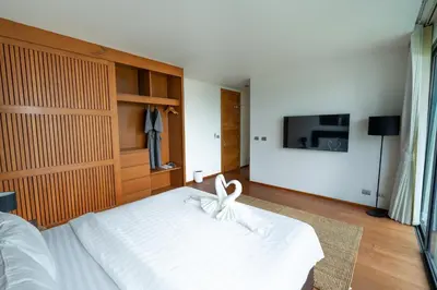 a bedroom with a white bed and a tv at \u62c9\u5a01Eva11\u4e09\u5367\u6c99\u6ee9\u522b\u5885 \u51fa\u95e8\u5c31\u662f\u5927\u6d77 \u4e09\u4e2a\u5367\u5ba4\u90fd\u662f\u6d77\u666f\u72ec\u536b in Phuket Town