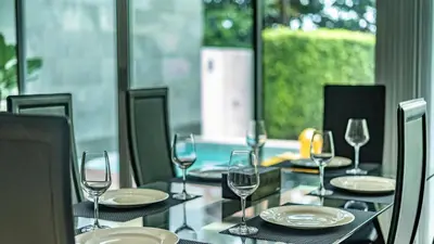 a table with wine glasses and plates on it at \u62c9\u5a01Eva11\u4e09\u5367\u6c99\u6ee9\u522b\u5885 \u51fa\u95e8\u5c31\u662f\u5927\u6d77 \u4e09\u4e2a\u5367\u5ba4\u90fd\u662f\u6d77\u666f\u72ec\u536b in Phuket Town