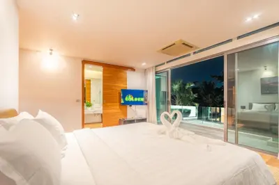 a bedroom with a white bed and a tv at \u62c9\u5a01Eva11\u4e09\u5367\u6c99\u6ee9\u522b\u5885 \u51fa\u95e8\u5c31\u662f\u5927\u6d77 \u4e09\u4e2a\u5367\u5ba4\u90fd\u662f\u6d77\u666f\u72ec\u536b in Phuket Town