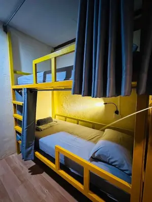 a bedroom with two bunk beds and a lamp at Easy Hostel in Phi Phi Don