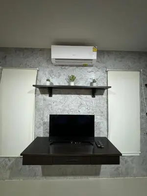 a living room with a fireplace with a television on a wall at Mimi Home in Ko Yao Noi