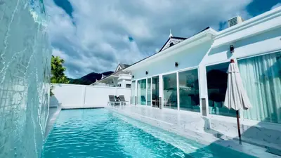 a swimming pool with an umbrella next to a building at Kamala Garden View Villas by Aladdin in Kathu