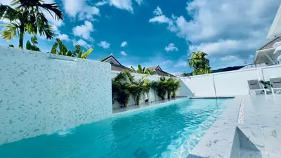 a swimming pool in a villa with palm trees at Kamala Garden View Villas by Aladdin in Kathu