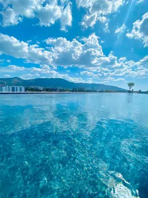 a large body of water with a tree in the middle at Cozy 1BR in Laguna Skypark Celeste Bangtao, Iinfinity Pool in Bang Tao Beach