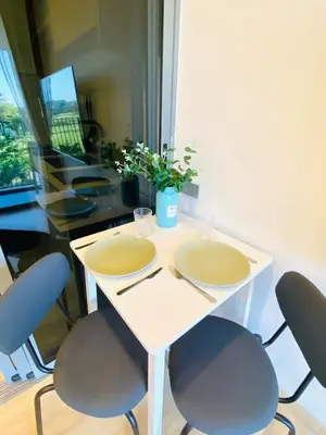 a white table with two chairs and a table with a plant at Cozy 1BR in Laguna Skypark Celeste Bangtao, Iinfinity Pool in Bang Tao Beach