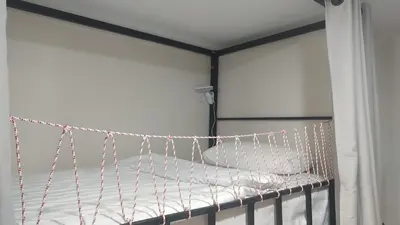 a bed in a room with chains on it at Bambus Restaurant, Bar & Hostel in Patong Beach