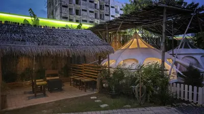 a patio with a table and chairs and tents at Bambus Restaurant, Bar & Hostel in Patong Beach
