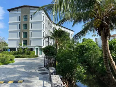 a white building with palm trees in front of it at Title V Palm View 4fl Pool Gym Hammam in Rawai Beach