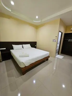 a bedroom with a large bed with white sheets at Samran Resort in Chalong