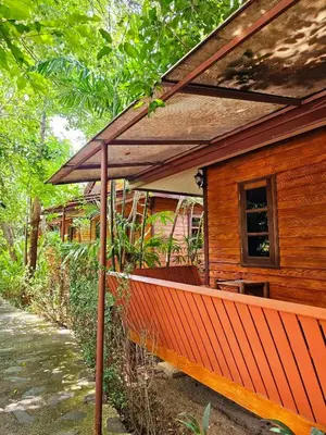 a porch of a house with an umbrella at Samran Resort in Chalong
