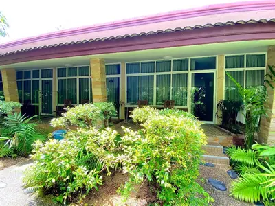 a building with large windows and bushes in front of it at Samran Resort in Chalong