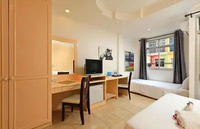 a hotel room with a desk and a bedroom at Gorgeous Boutique Room in Patong Beach
