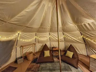 a tent with two chairs and lights in it at Bambus Restaurant, Bar & Glamping in Patong Beach
