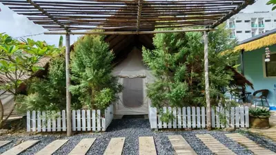 a small house with a white fence and trees at Bambus Restaurant, Bar & Glamping in Patong Beach